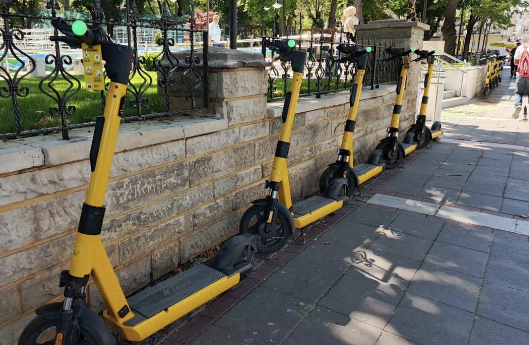 Kaldırımda yan yana park edilmiş kiralık elektrikli scooterlar